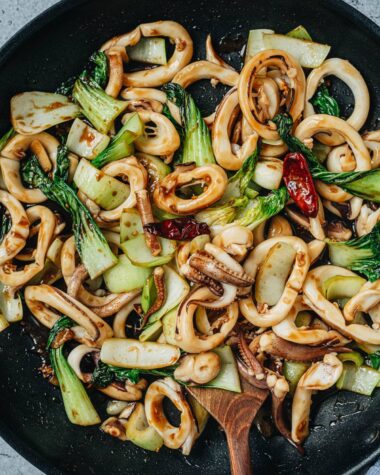 Squid and bok choy stir fry in a pan close up